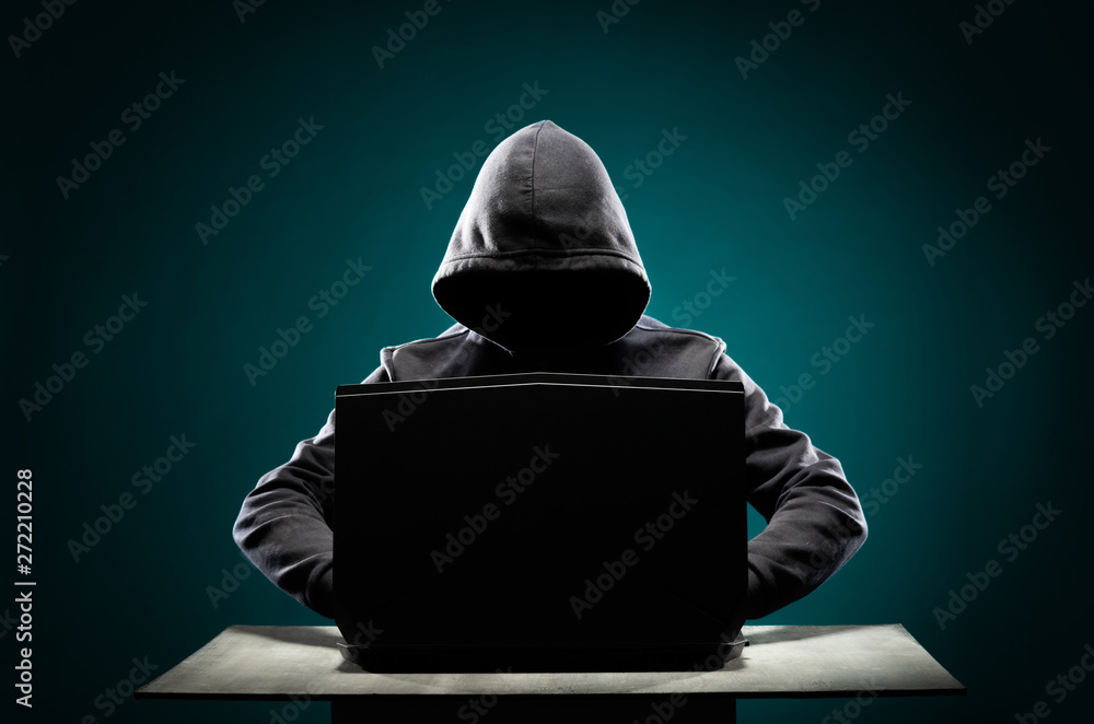 Computer hacker in hoodie. Obscured dark face. Data thief, internet fraud,  darknet and cyber security concept. Stock Photo | Adobe Stock
