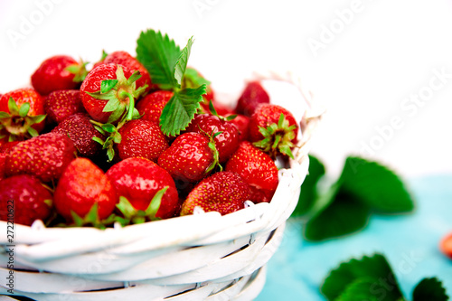 Ripe red strawberries on blue table  Strawberries in white basket. Fresh strawberries. Beautiful strawberries. Diet food. Healthy  vegan. Copy space.