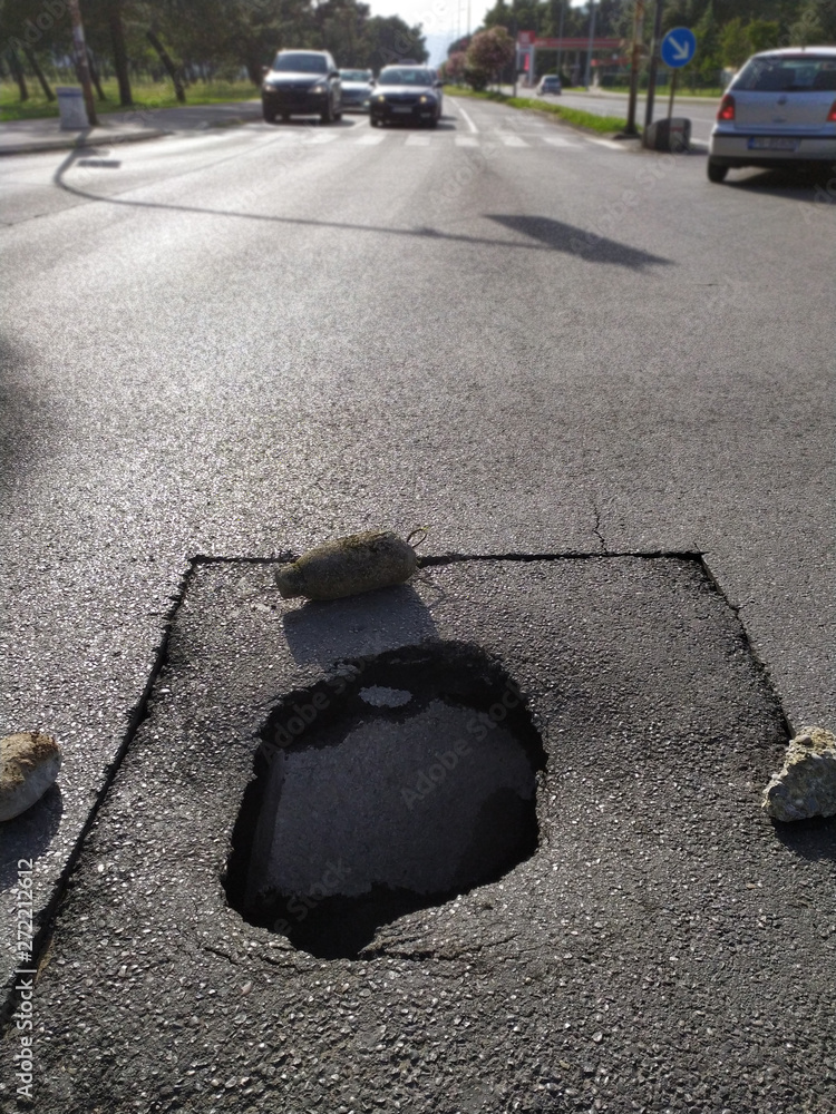 Deep unmarked pothole in the middle of an intersection. Stock Photo ...