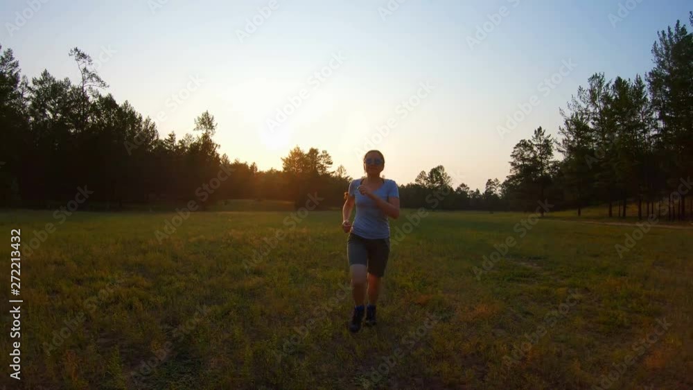 Girl running on meadow grass at sunset. Slow motion Girl running on meadow grass at sunset. Slow motion