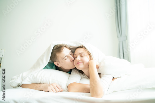 Beautiful loving couple relaxing on bed