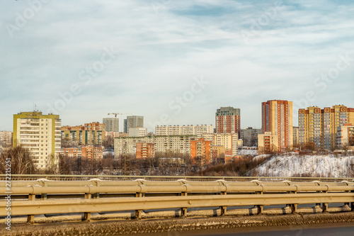 Before us is one of the districts of the city of Perm. Behind the road are visible high-rise buildings. In the distance, a construction crane is visible.