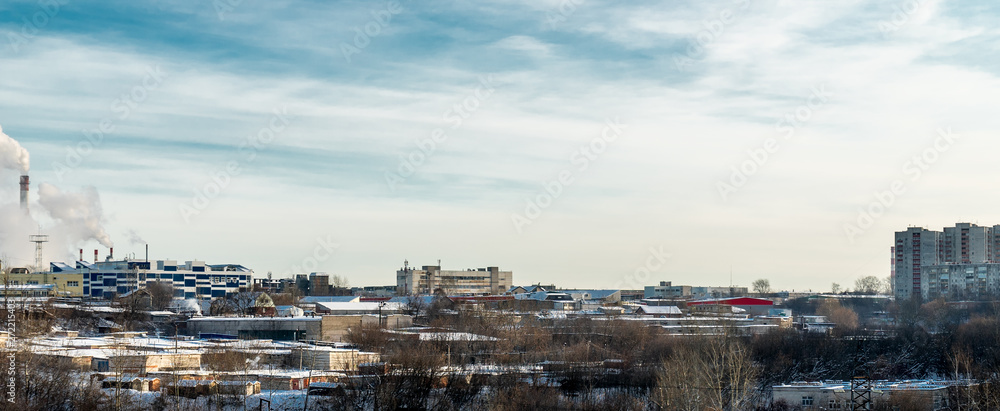Outskirts Of Perm. In the foreground trees and a variety of low buildings. In the distance you can see Smoking chimneys, industrial buildings. On the right we see houses.