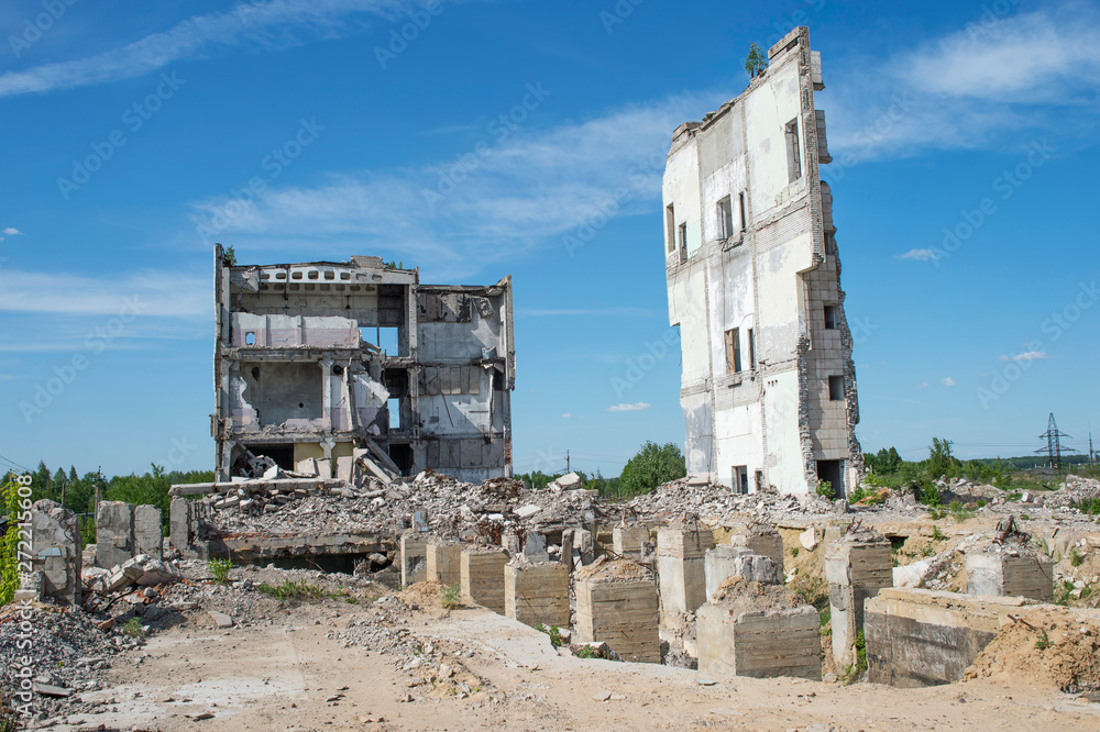 Remains of a large building with concrete Foundation piles in the foreground. Background