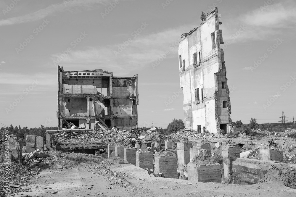 Remains of a large building with concrete Foundation piles in the foreground. Background. Black and white