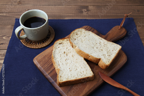 木のまな板にのせた トースト くるみ入り 食パンとコーヒー テーブル
