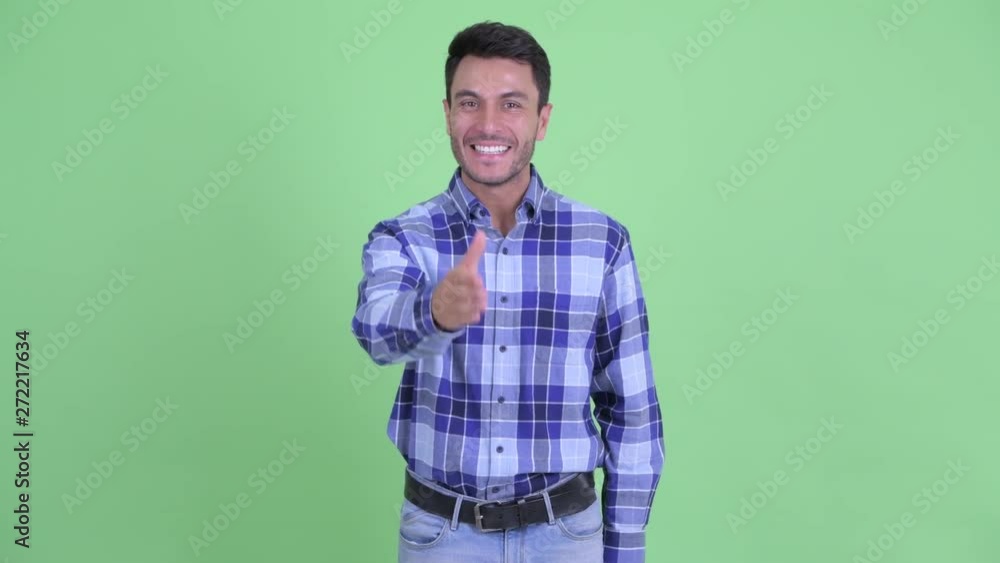 Happy young handsome Hispanic man giving handshake Happy young handsome Hispanic man giving handshake