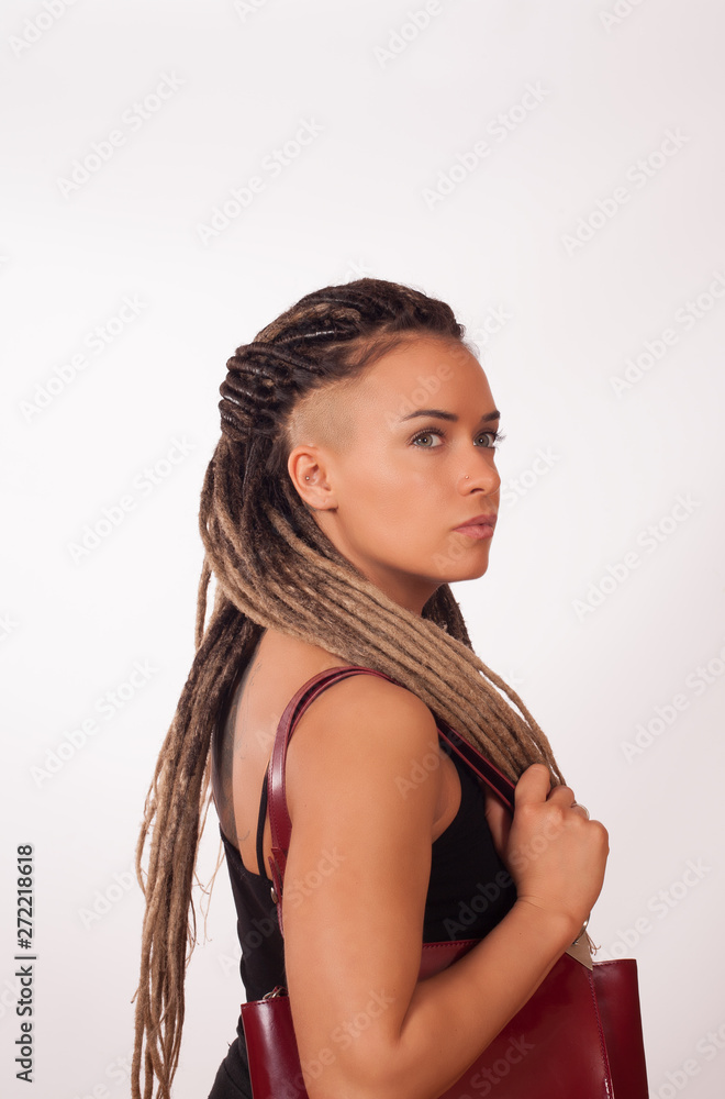 Portrait of a European girl with African pigtails, shaved temples and a dark red bag on a white background Portrait of a European girl with African pigtails, shaved temples and a dark red bag on a white background