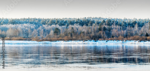 Beyond the river Kama, on which floating ice, is pristine winter forest.