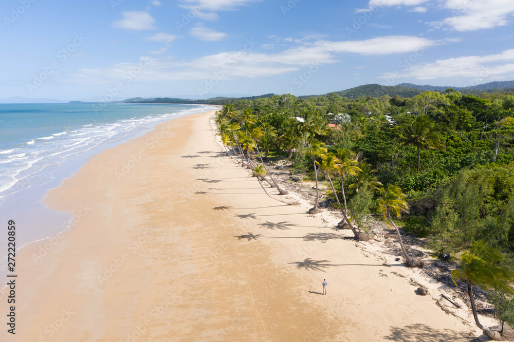 Aerial top view of beach with white sand, beautiful palm trees and warm turquoise tropical water