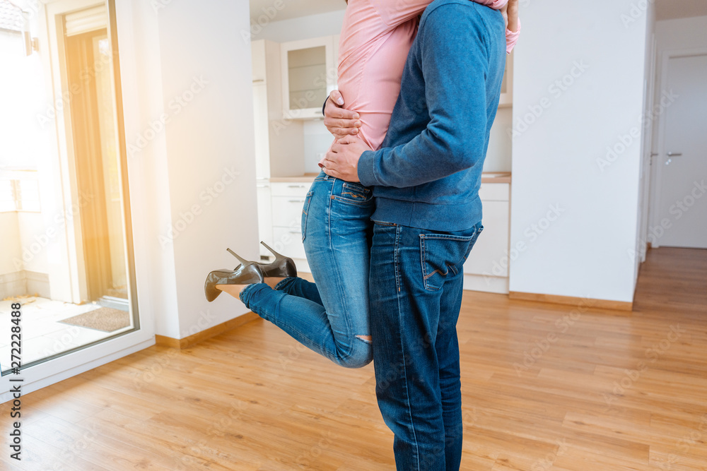 Woman hugging her man being happy in the new apartment