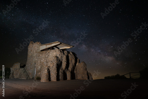 The galaxy of the Milky Way with many stars over an old historic defensive structure with a masonry shooting range near the Spanish city of Cartagena at night.