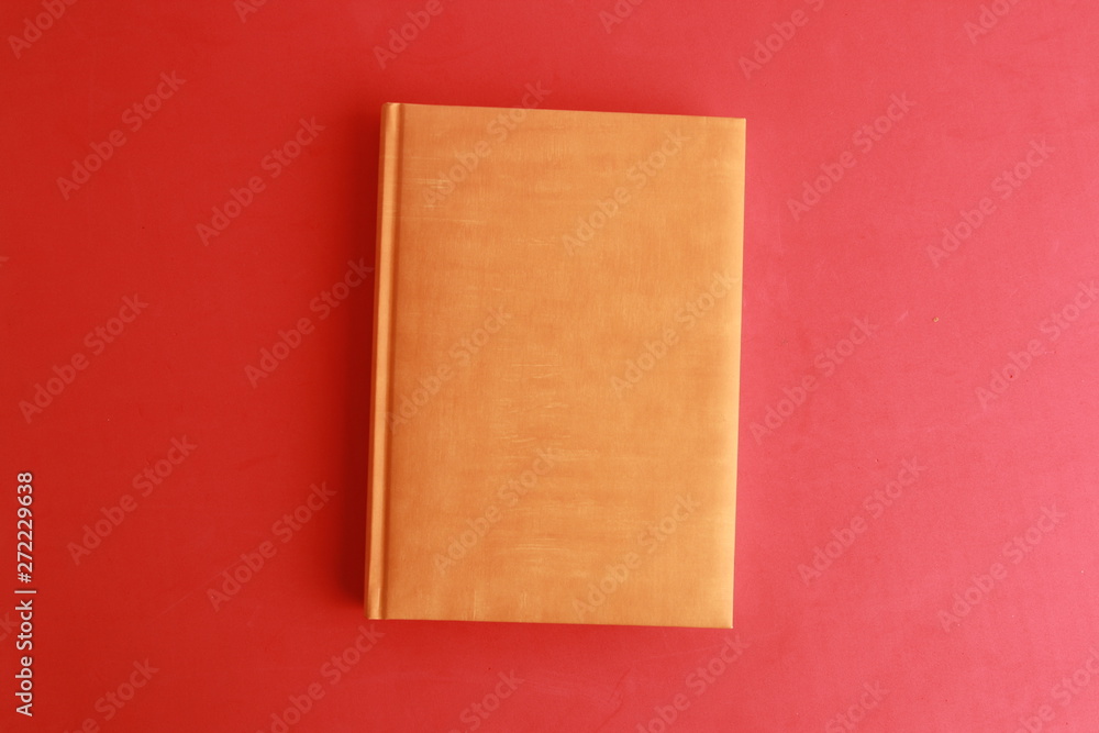 Fototapeta premium book with orange cover on colorful background