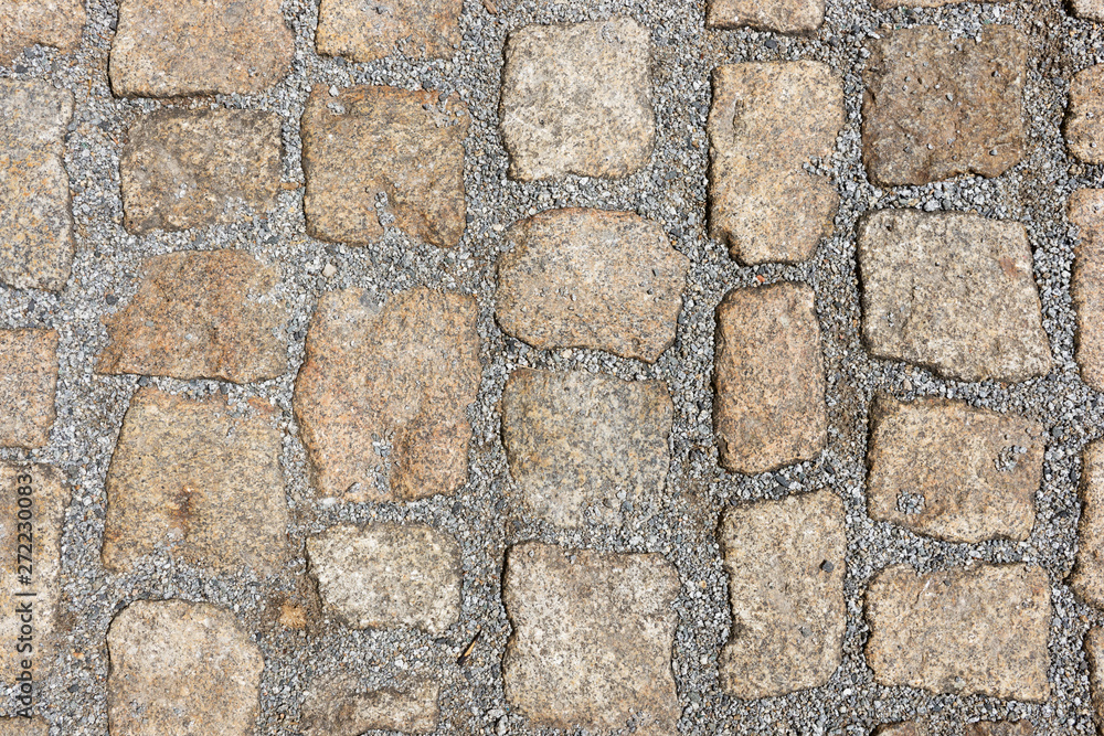 Fototapeta premium Old stone pavement texture. Granite cobblestones pavement background. Abstract background of old cobblestone