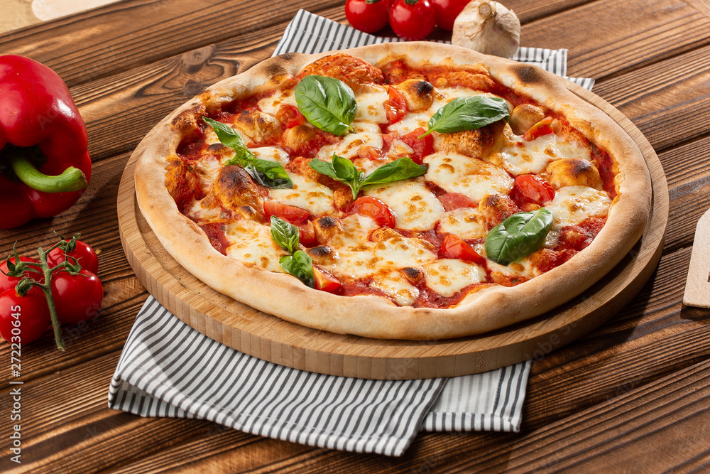 Pizza Margherita on wooden background, top view. Pizza Margarita with Tomatoes, Basil and Mozzarella Cheese close up.