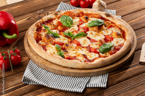 Pizza Margherita on wooden background, top view. Pizza Margarita with Tomatoes, Basil and Mozzarella Cheese close up. 