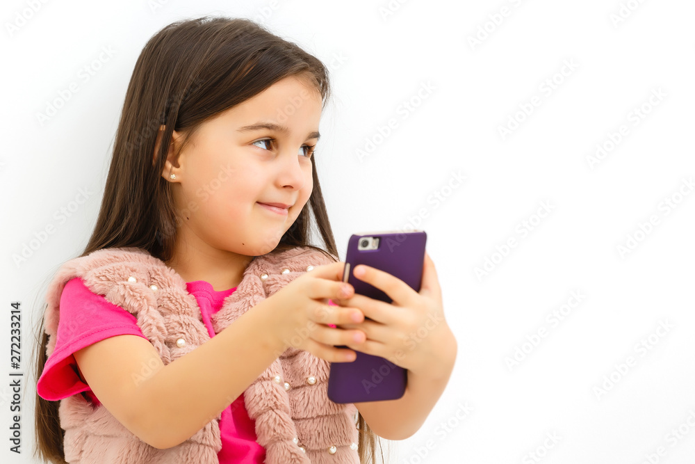 Little girl holding a smart phone against white background Little girl holding a smart phone against white background