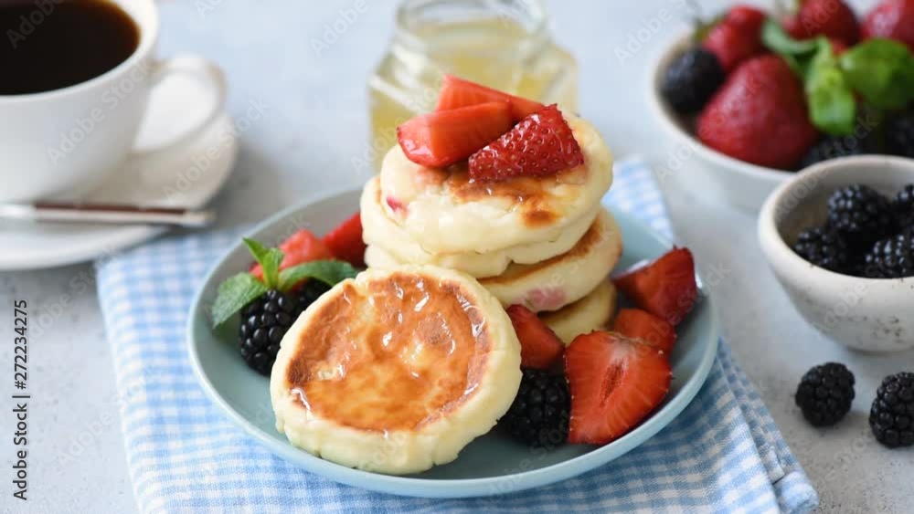 Honey pouring over pancakes in slow motion, closeup view footage. Tasty and healthy breakfast