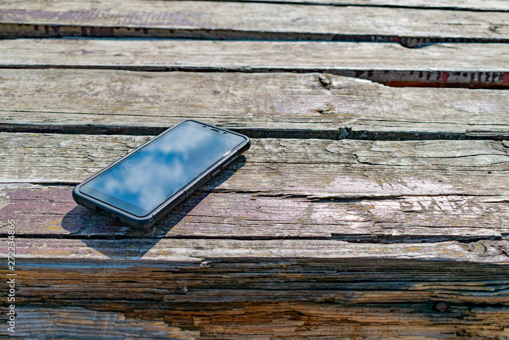 Cell phone lies on the old table Cell phone lies on the old table