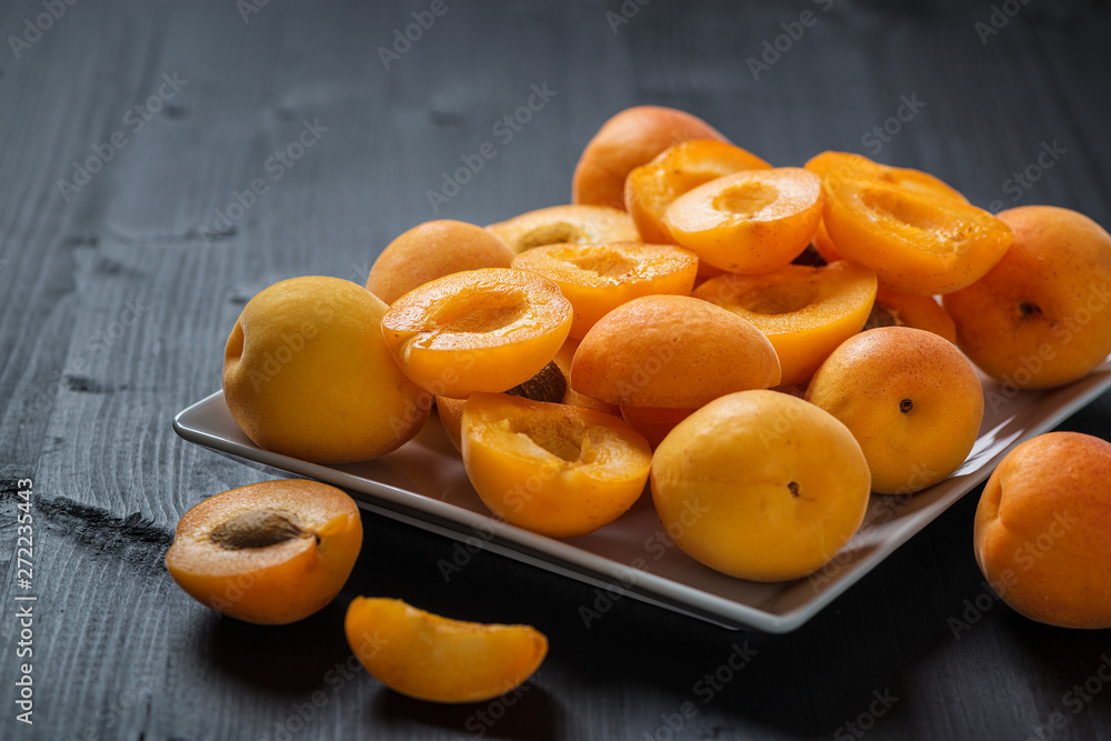 Fresh apricots on a black wooden table.