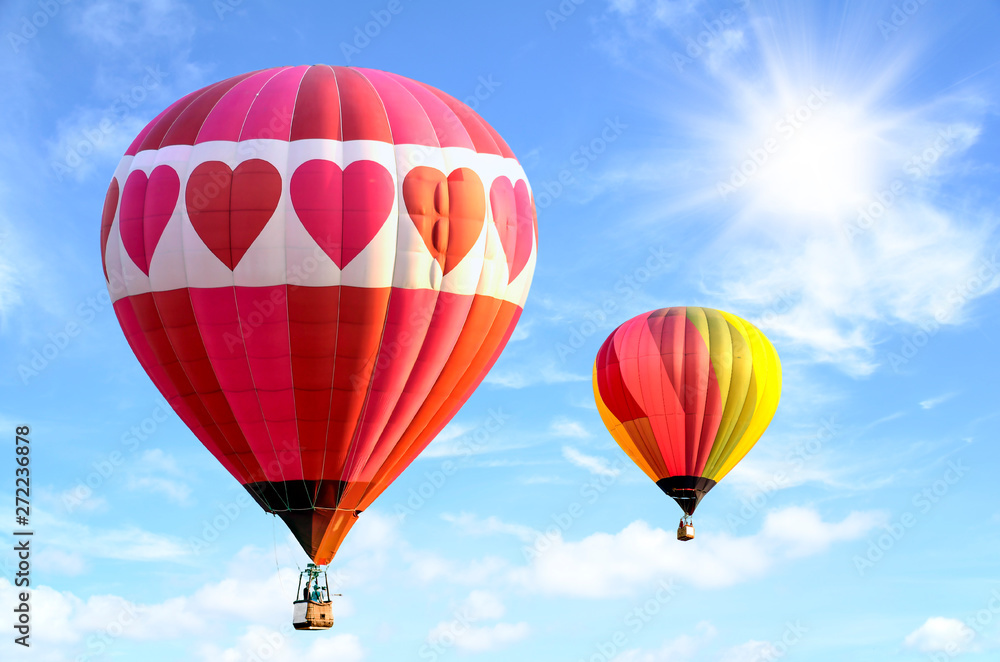 Fototapeta premium Colorful hot air balloon over bright sky with clouds. Hot air balloon and blue sky background.