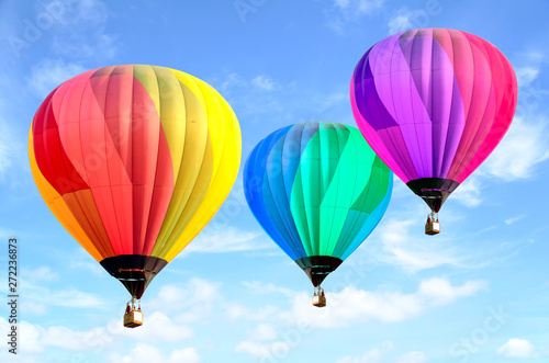 Colorful hot air balloon over bright sky with clouds.