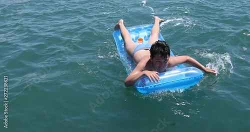 Portrait of a  cute happy boy in swimming suit with inflatable matress enjoying summer day. Loking at the camera posing and smiling