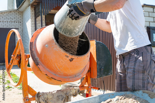 Schilderij op canvas builder working with shovel during concrete cement solution mortar preparation
