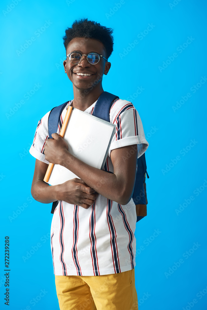 Happy Afro American student posing with backpack in studio Happy Afro American student posing with backpack in studio