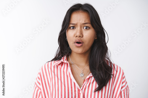 Concerned female friend hearing disturbing news feeling empathy and pitty standing worried and upset frowning open mouth, feeling sorry for terrible situation happening standing against white wall photo