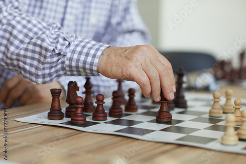 Photography Tanned wrinkled hand of old professional grandmaster making decisive chess move