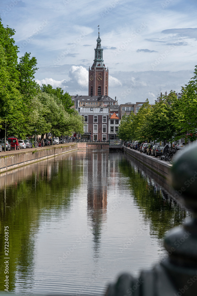 Saint James church reflected on the canal calm water nested to the royal stable, in The Hague
