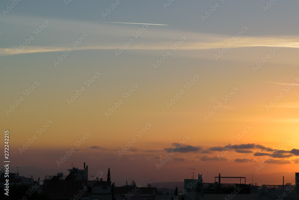 Sunset with cityscape in dark shadow, blue orange soft colors