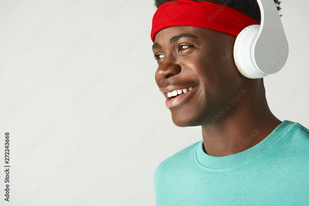 Happy Afro American guy standing with headphones Happy Afro American guy standing with headphones