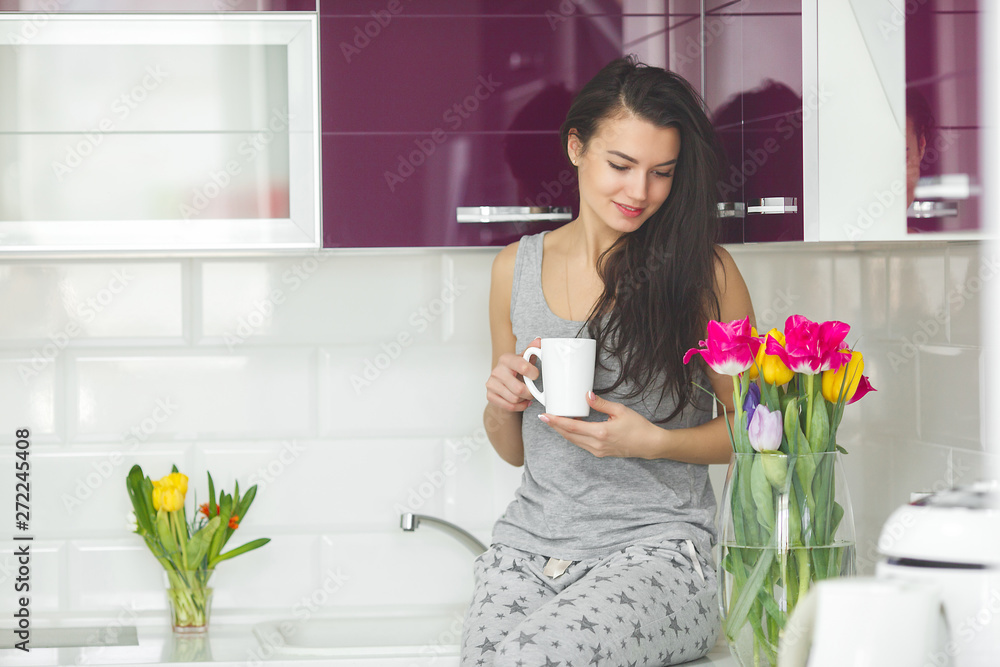 Young beautiful woman in the early morning having coffee on the kitchen. Fresh morning. Bracing drink. Fees for work. Awake lady. Young beautiful woman in the early morning having coffee on the kitchen. Fresh morning. Bracing drink. Fees for work. Awake lady.