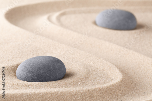 Zen garden meditation stone. Round rock on sandy texture background. Yoga or mindfulness concept. .