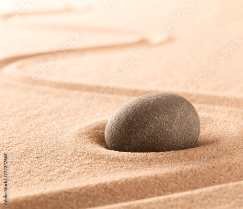 Spa wellness or mindfulness stone and sand garden. Concentration or focus point for spiritual balance and purity of mind and soul. Sandy background with copy space. .