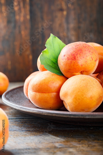 Delicious ripe apricots in a plate on the table close-up.