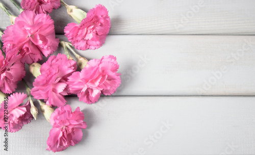 Floral background. Carnation flowers on a wooden background. A place for an inscription.