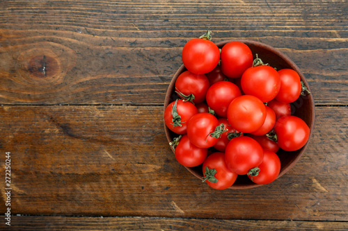 Fresh tomatoes in a plate on a wooden background. Harvesting tomatoes.