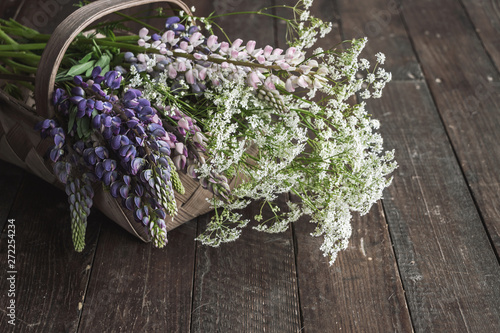 Fototapeta Naklejka Na Ścianę i Meble -  wild summer flower bouquet in basket on wooden floor