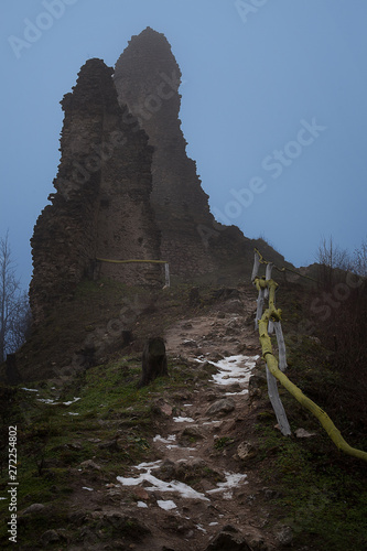 Ruin of Korlatko castle in Western Slovakia. Central Europe. Forest footpath with handrail to the rubble of old ancient castle. Artistic romantic photo of evening track to the ruin. photo