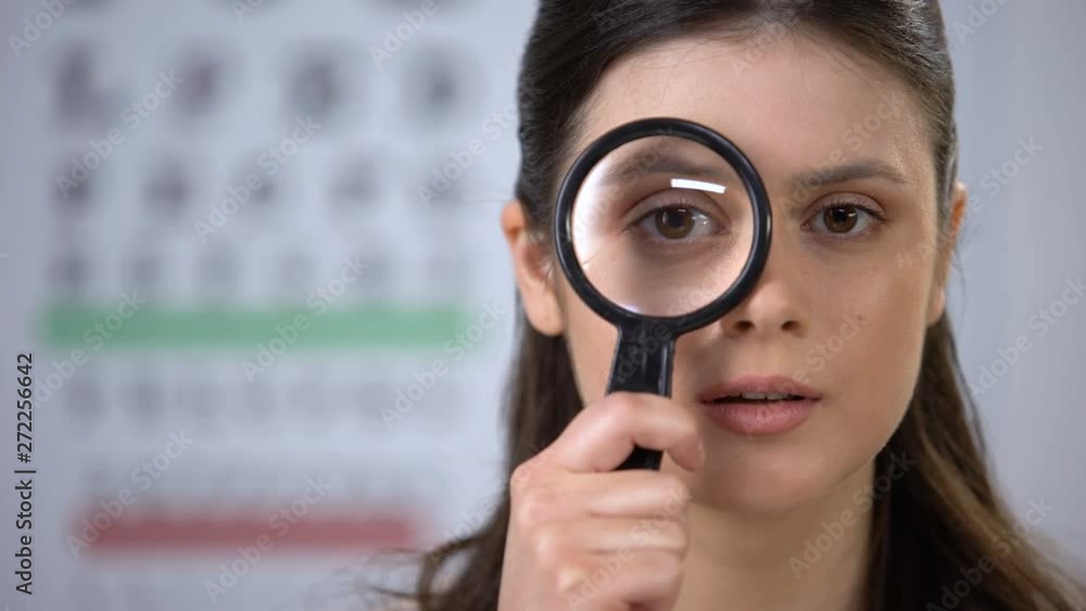Attractive lady looking through lens and smiling, eye cornea genetics, treatment Attractive lady looking through lens and smiling, eye cornea genetics, treatment