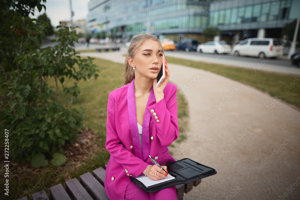 Business woman sitting on a bench in the street