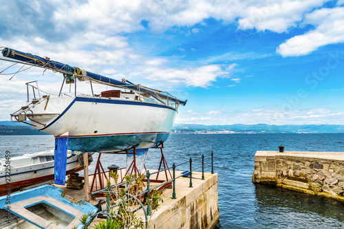 Hafenszene Lovran, Kroatien mit Rijeka im Hintergrund