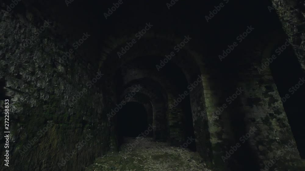 Dark stone dungeon in medieval castle. Steadicam shot