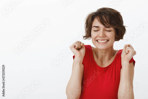 Excited girl cannot wait tomorrow concert feeling amused thrilled close eyes triumphing smiling broadly clench fists celebration win gesture achieve incredible positive result win, white background