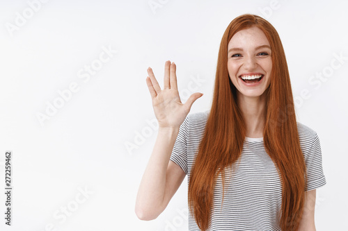 Cute carefree young redhead teenage geek girl like watching tv series fan fantazy movies greet friends raising hand show spok gesture smiling broadly have fun welcoming guest party, white background