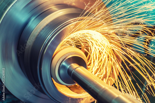 Fotografia Internal grinding of a cylindrical part with an abrasive wheel on a machine, sparks fly in different directions