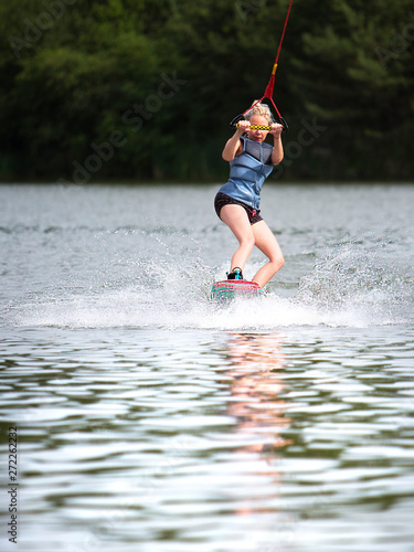 Fototapeta Naklejka Na Ścianę i Meble -  Young pretty slim woman riding wakeboard in summer 